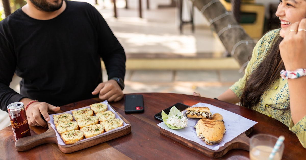 Indian couple sitting across from each other at a cafe, having a deep conversation over chai