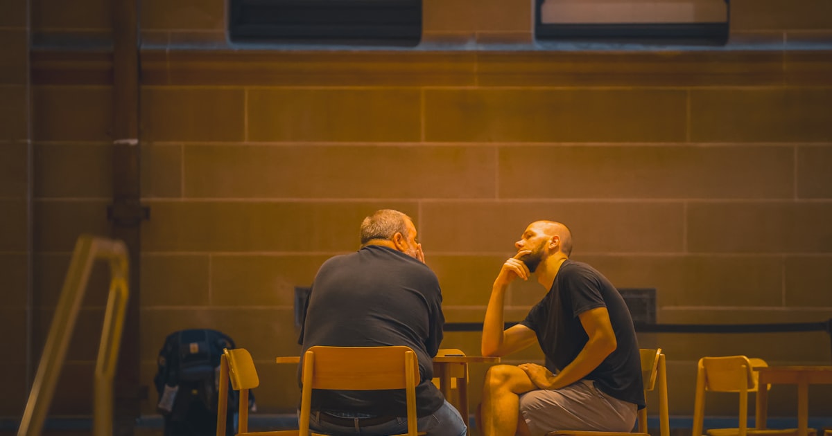 A warm scene of two people sitting together having a deep conversation over chai, comfortable and relaxed