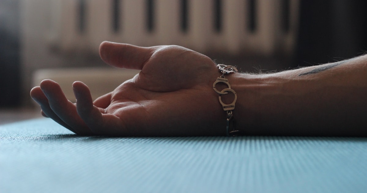 A person's hand resting on a table with a radiator in the