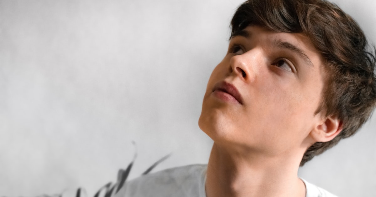 man wearing gray top looking up