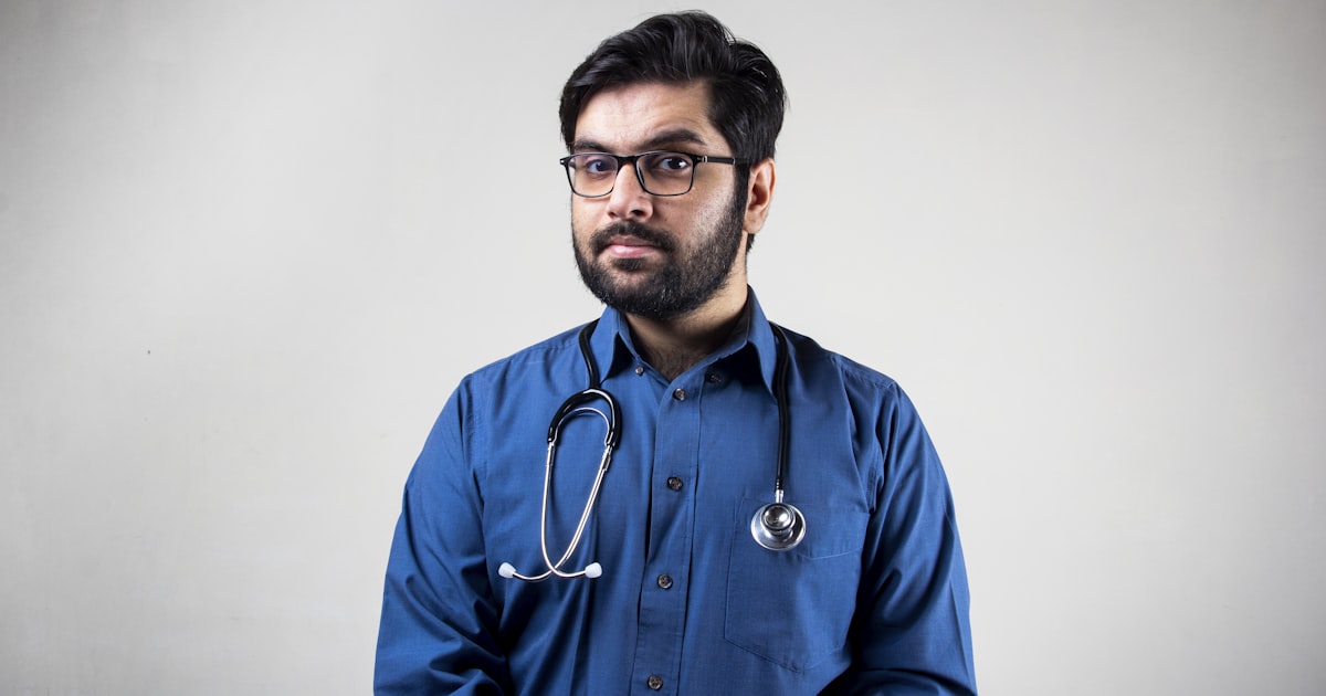 man in blue dress shirt wearing black framed eyeglasses
