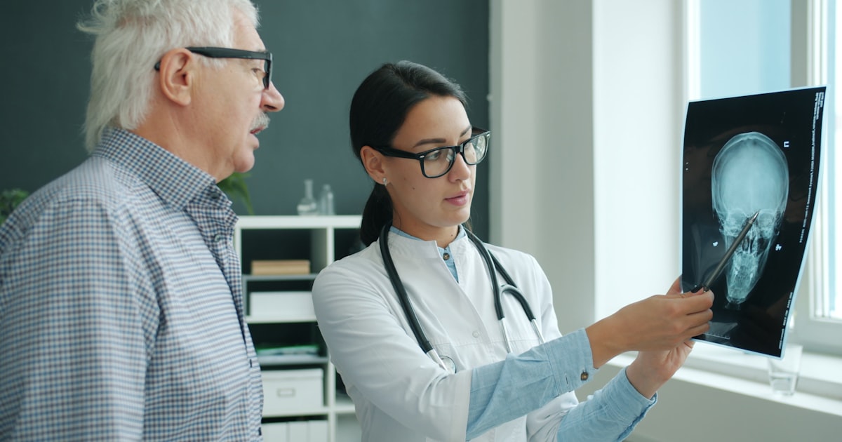 Doctor shows x-ray scan to an elderly patient.