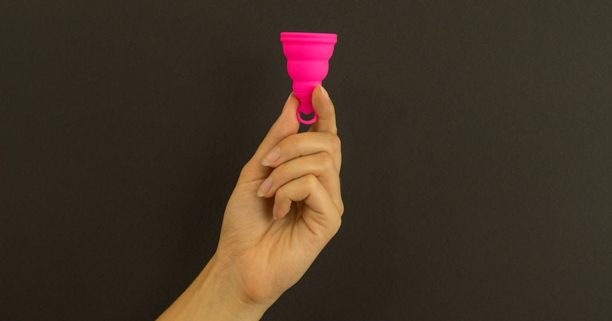 a person holding a pink cup in their hand