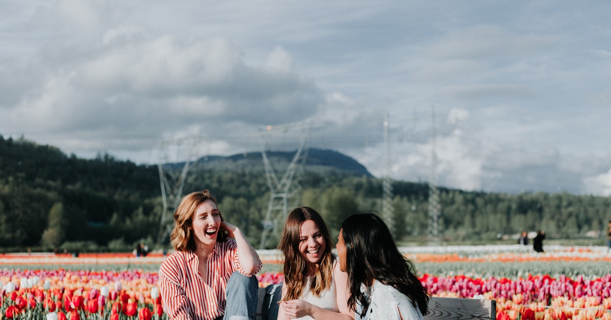 3 women sitting on bench near the flowers